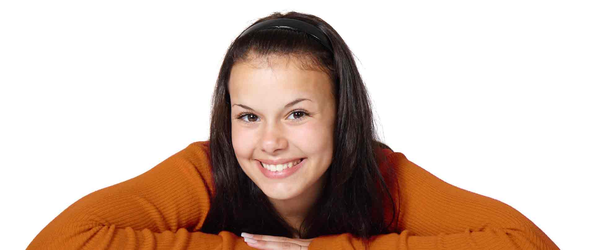 girl in orange sweater smiling