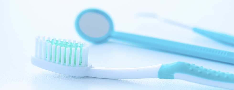 blue toothbrush, tooth mirror, and other dental utensils